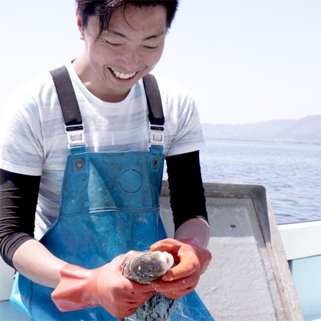 琵琶湖のニゴイを笑顔で網から外す中村水産代表